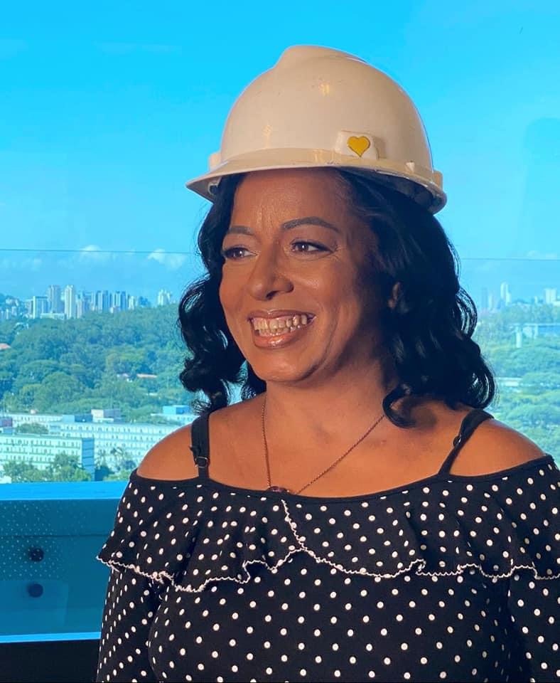 Márcia, fundadora do Projeto Mestre da Solidariedade, usando capacete de obra